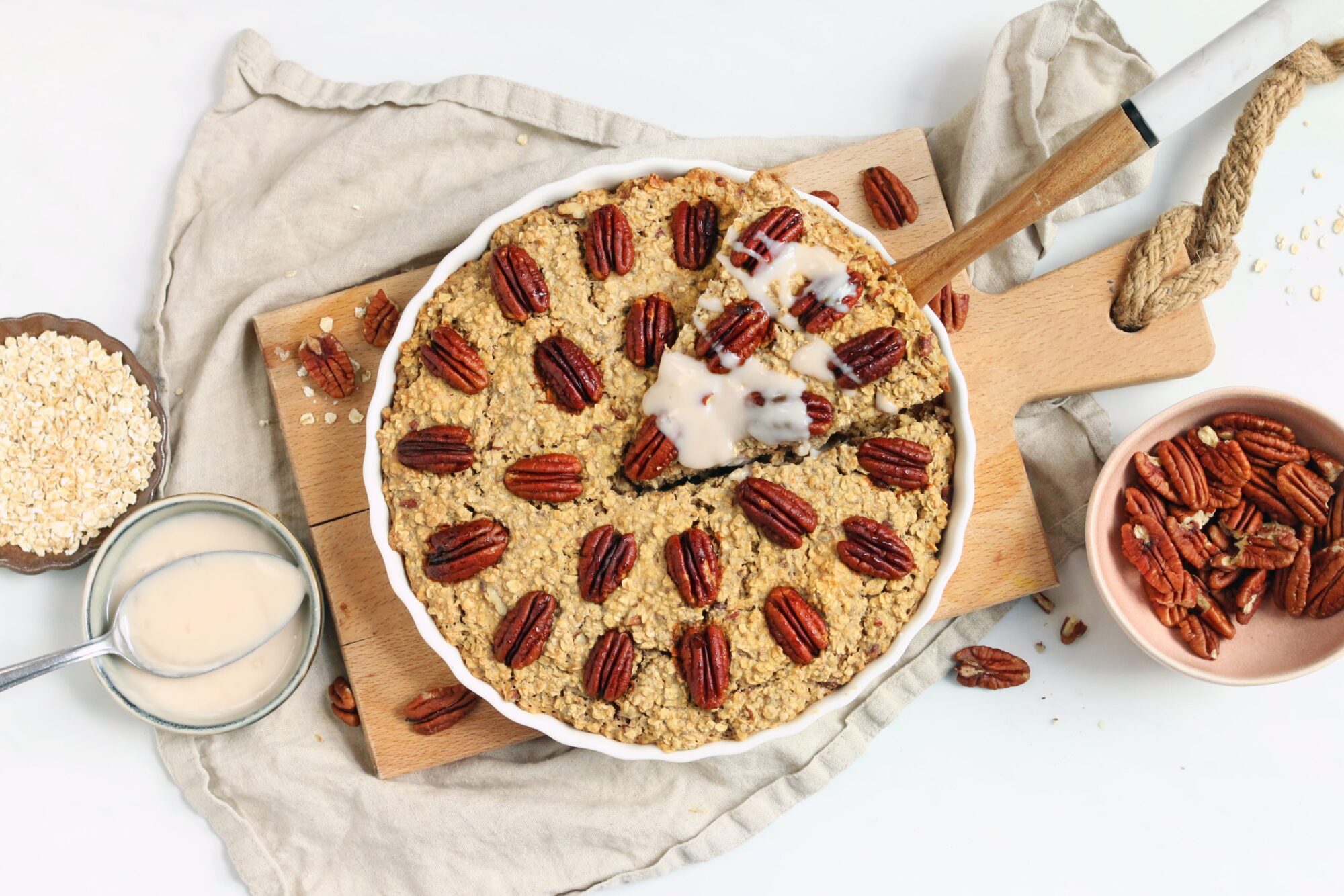 Foto van een pecan pie baked oats. Er wordt net een stukje uitgehaald