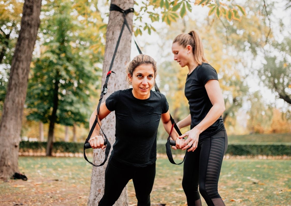 Vrouwelijke personal trainer traint vrouw in een park