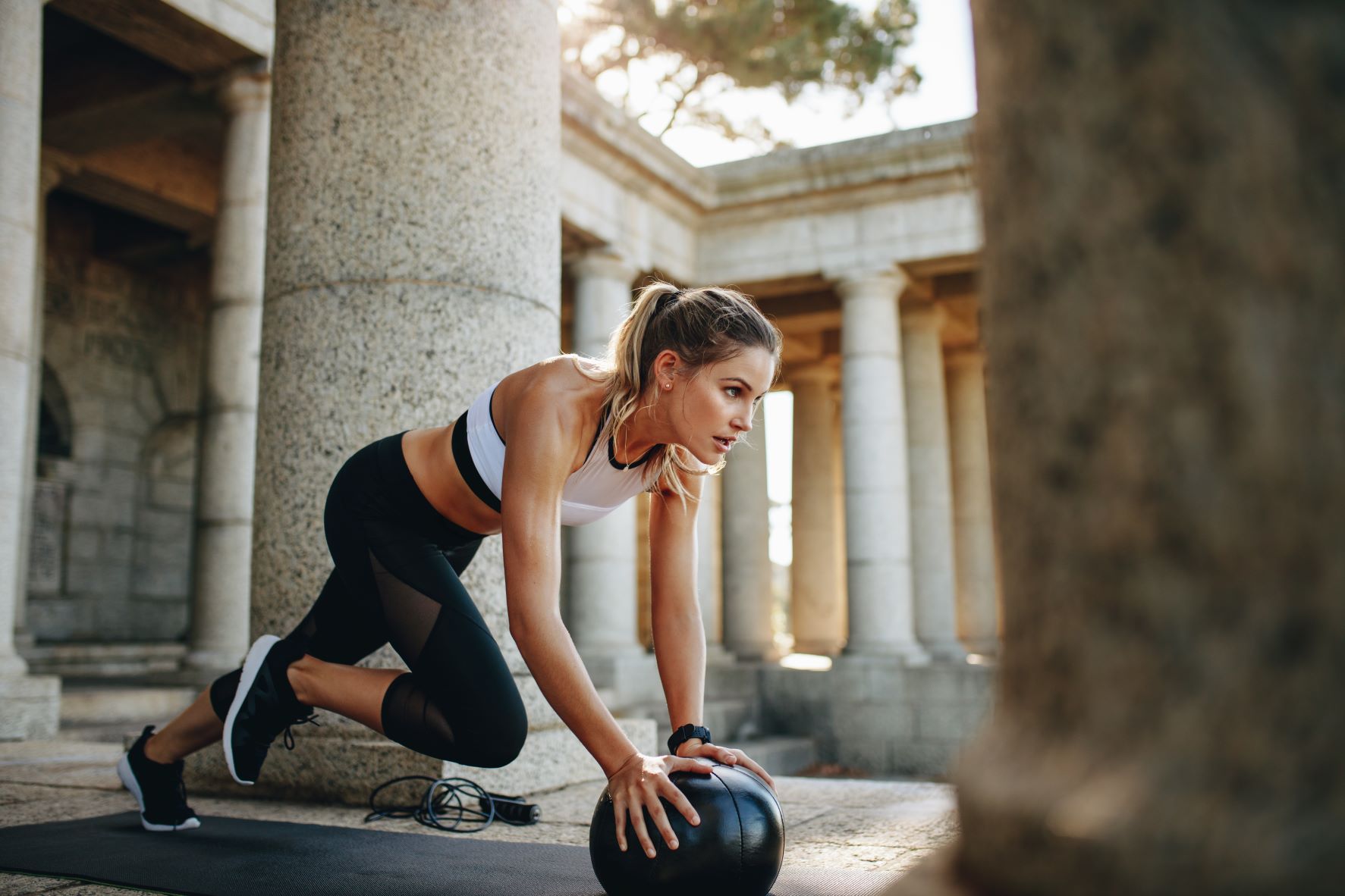 Vrouw traint buiten met een medicine ball