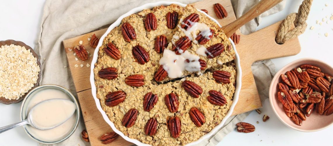 Foto van een pecan pie baked oats. Er wordt net een stukje uitgehaald